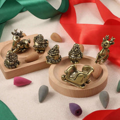 Brass Christmas sled and festive ornaments including reindeer and Santa figurines on a wooden tray.