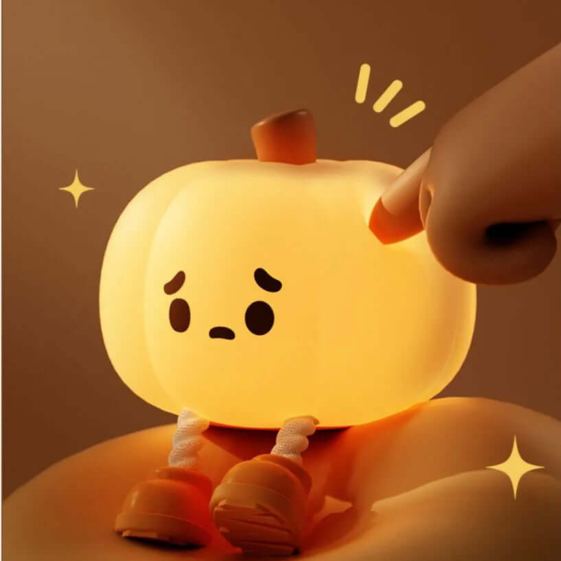 Cute silicone pumpkin night light with a sad face, glowing softly, ideal for Halloween kids' decor and gifts.