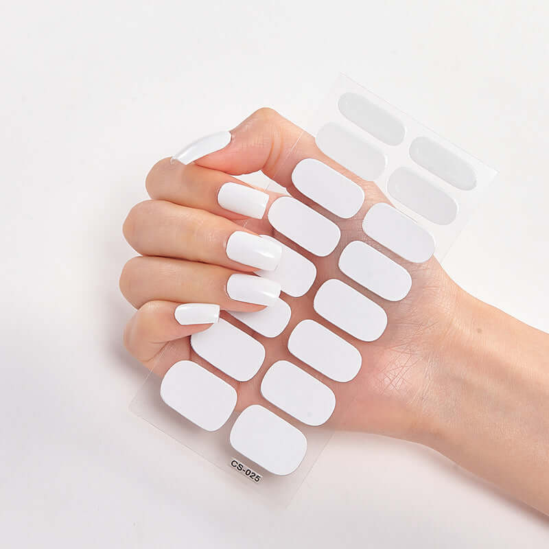 Hand holding Pure Color 16 Nail Stickers in white, demonstrating sleek nail art options for stylish designs.