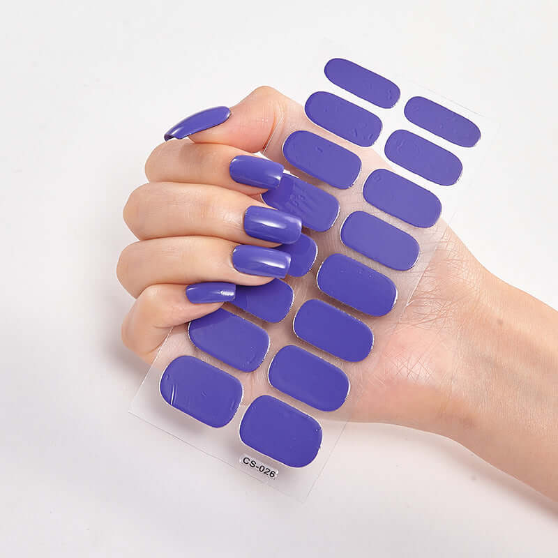 A hand displaying purple Pure Color 16 Nail Stickers CS-026 on long nails for stylish manicures.