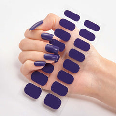 Hand holding Pure Color 16 solid purple nail stickers on a translucent sheet.