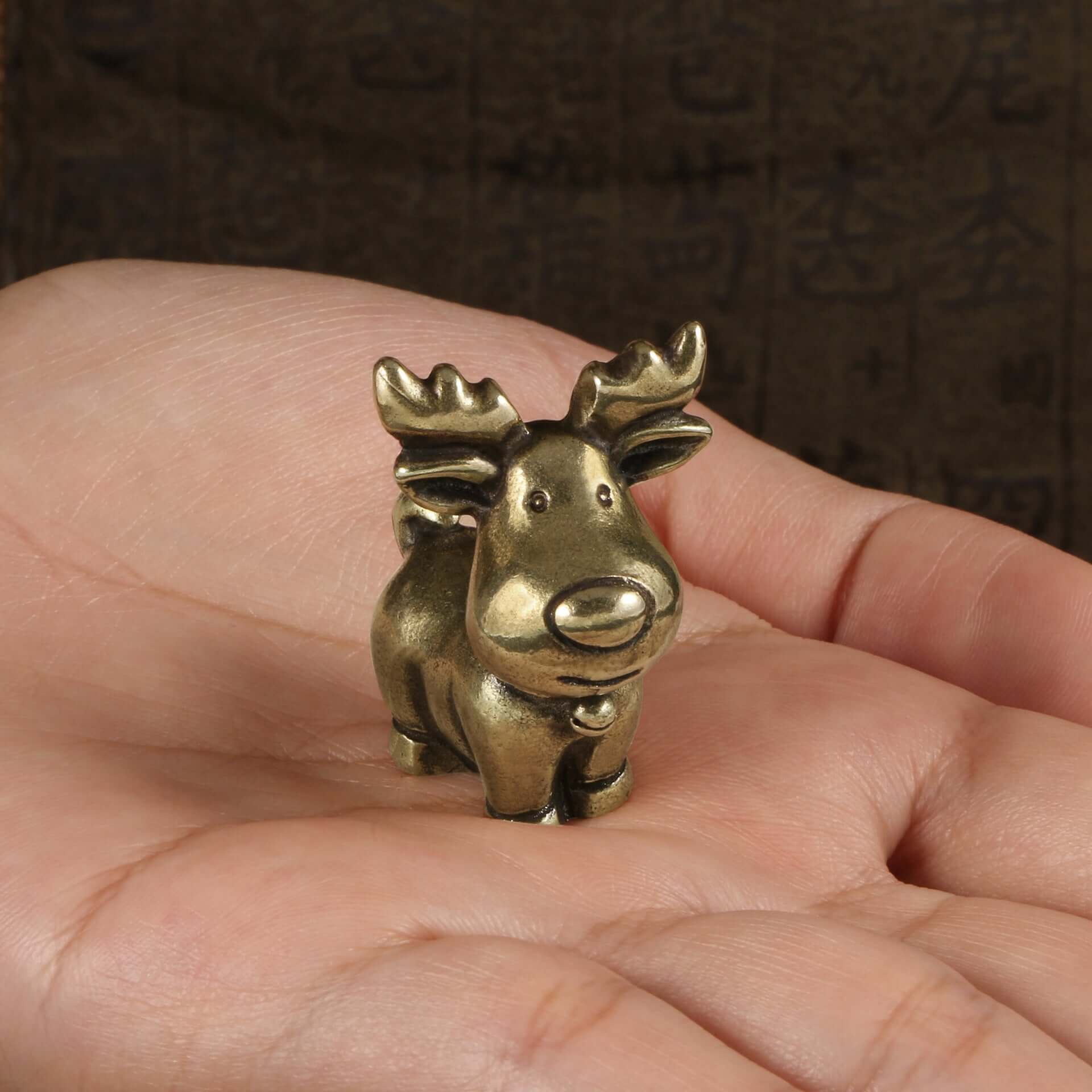 Antique brass Santa figurine held in hand, perfect for Christmas decor and crafts.