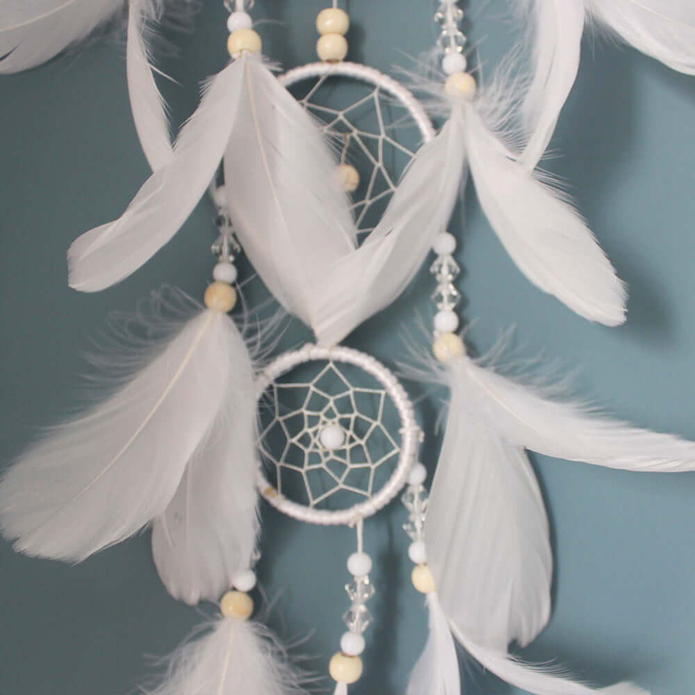 Elegant Indian dreamcatcher pendant with white feathers and beads for home decoration.