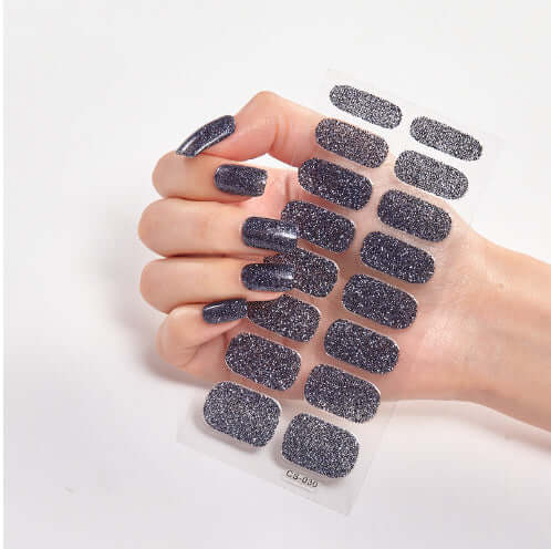 Hand displaying Pure Color 16 nail stickers CS003 with sparkling dark finish.