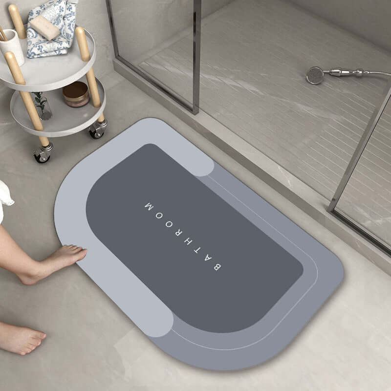 Modern oval bathroom mat in gray, featuring absorbent and quick-drying properties, ideal for home use.