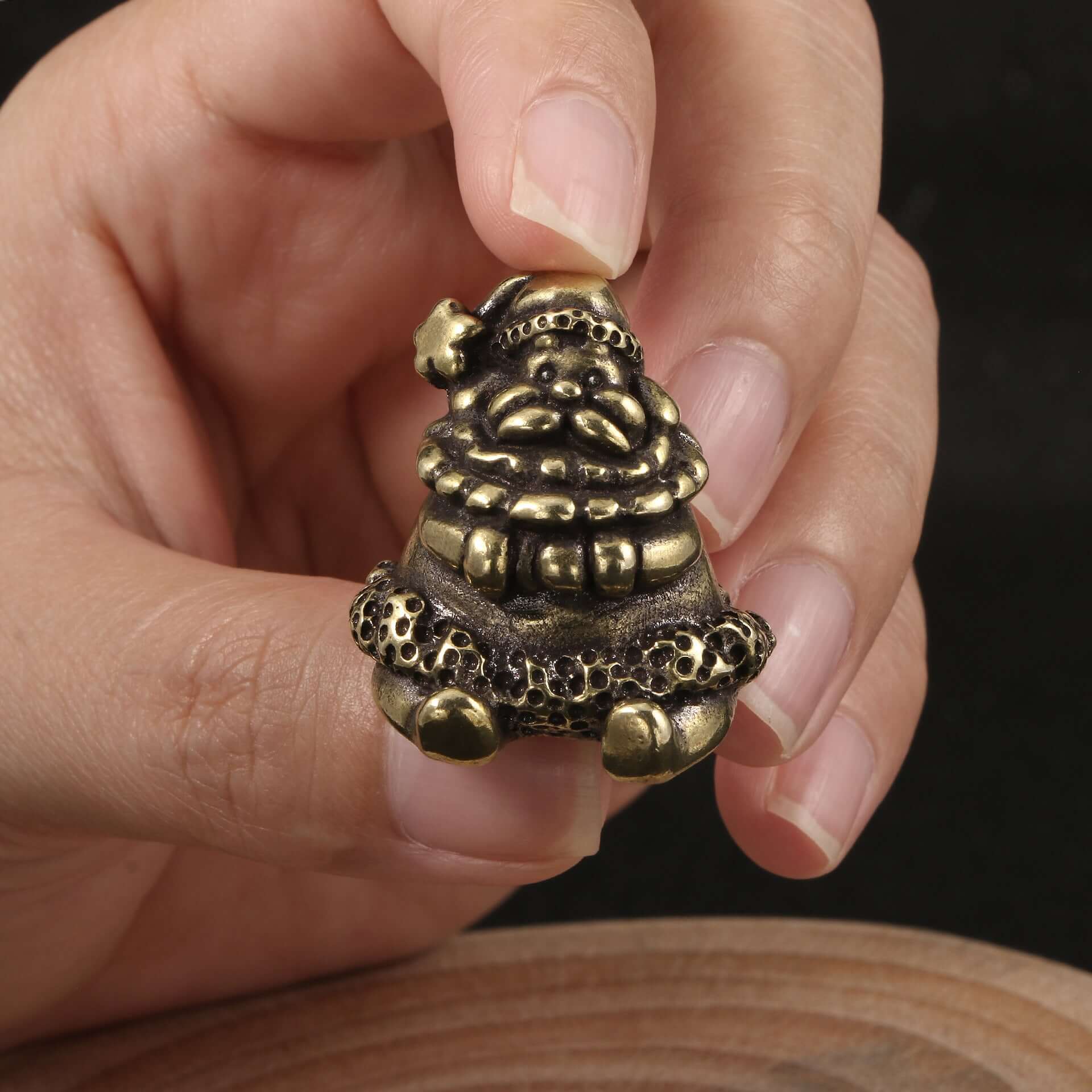 Antique brass Santa figurine held in hand, perfect for Christmas decor and crafts.