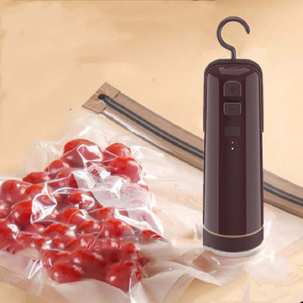 Portable electric vacuum sealer with attachment on vacuum storage bag filled with cherry tomatoes.