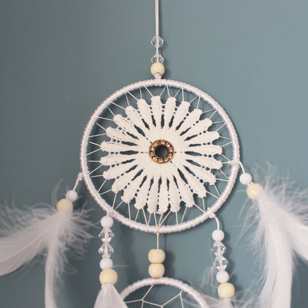 Elegant Indian dreamcatcher pendant in black and white, featuring feathers and beaded accents for home decoration.