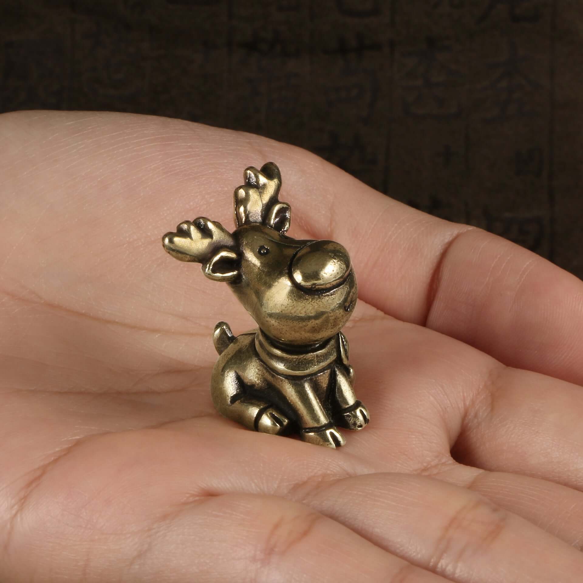 Antique brass Santa figurine held in hand, perfect for Christmas decor and crafts.