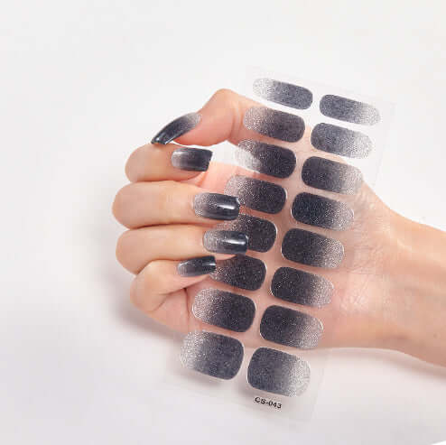 Hand holding pure color 16 nail stickers in gradient grey shades, showcasing stylish nail design options.