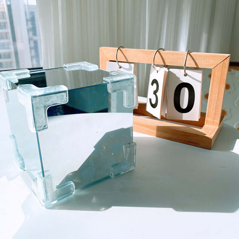Mirror cube decorative lamp beside a wooden calendar displaying the date 30, showcasing modern home decor.