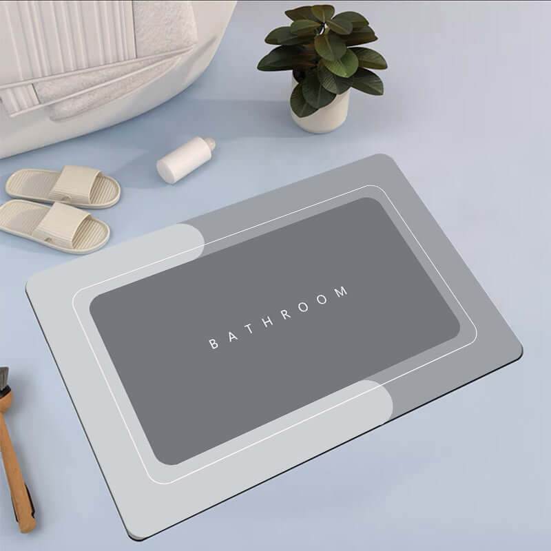 Modern gray bathroom mat with text 'BATHROOM' on it, designed for absorbency and quick drying.