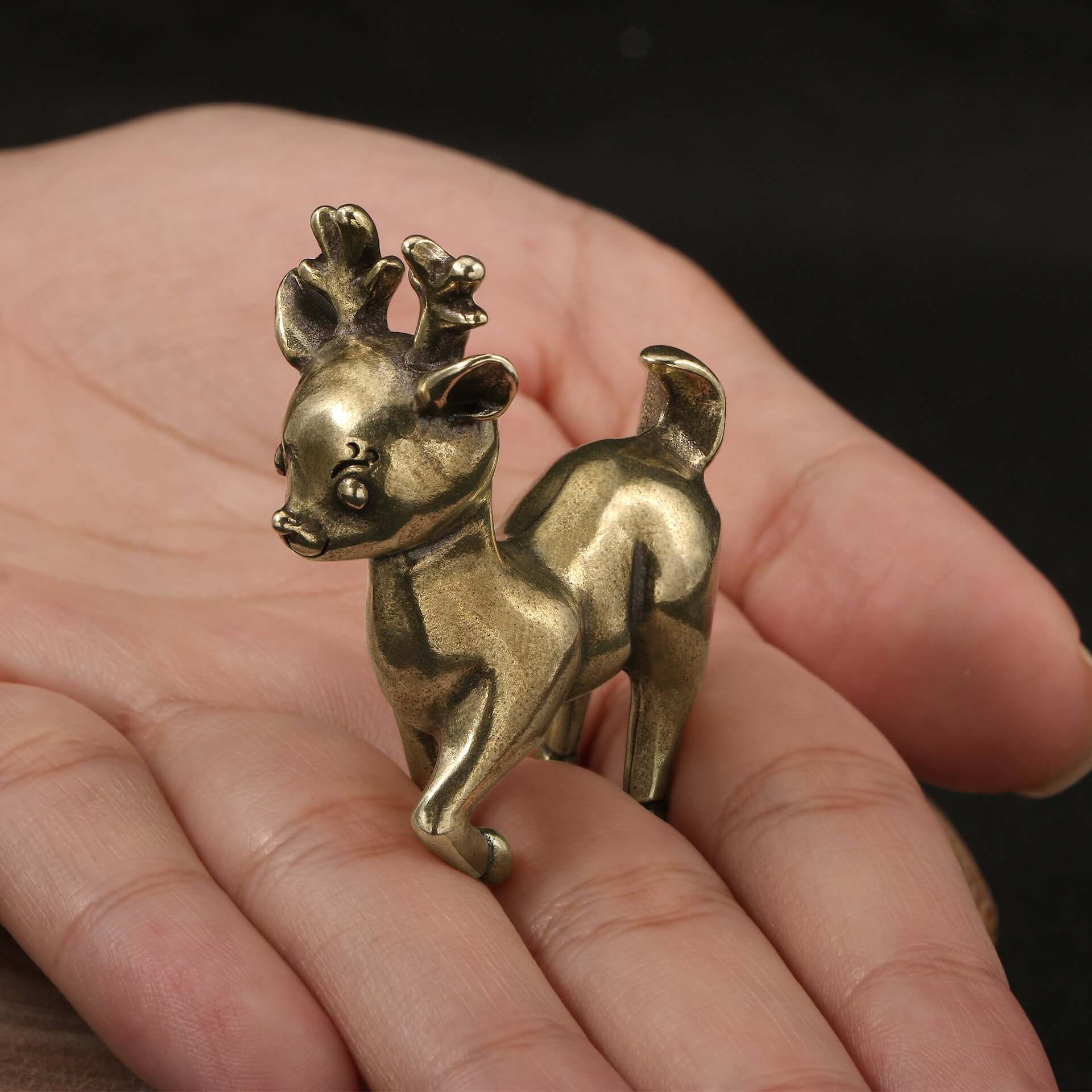 Antique brass reindeer ornament held in hand, ideal for Christmas décor and festive decorations.