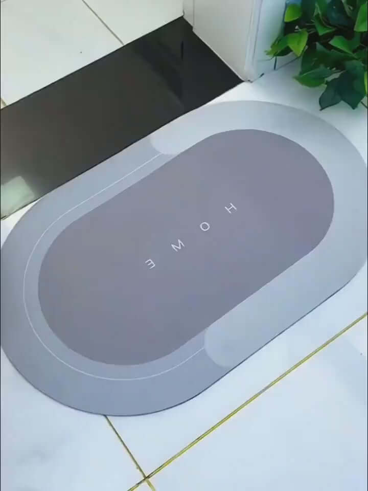 Modern oval floor mat with 'HOME' text, quick-drying, in elegant gray, suitable for home entryways and bathrooms.