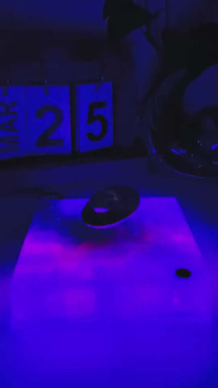 Levitating UFO Color Galaxy Lamp glowing with blue and purple lights, creating a cosmic ambiance on a table.