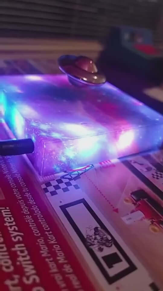 Levitating UFO color galaxy lamp with magnetic suspension and vibrant lights on a table.