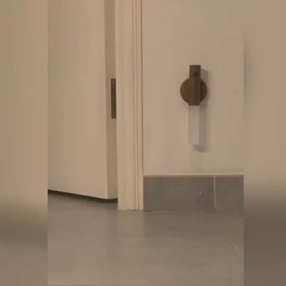 Magnetic LED night light mounted on wall near door, designed for energy-efficient lighting.