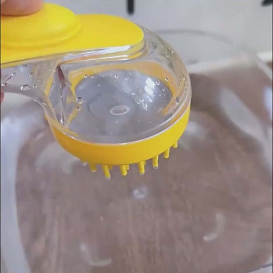 Close-up of a yellow pet bath brush with a clear soap container for easy grooming and cleaning.