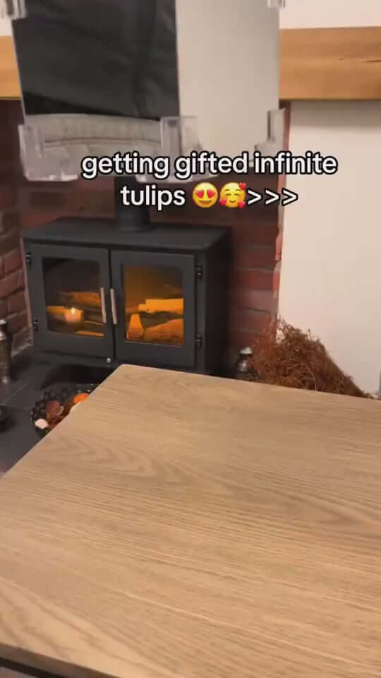 Cozy home interior with a fireplace and wooden table, featuring the phrase 'getting gifted infinite tulips'.