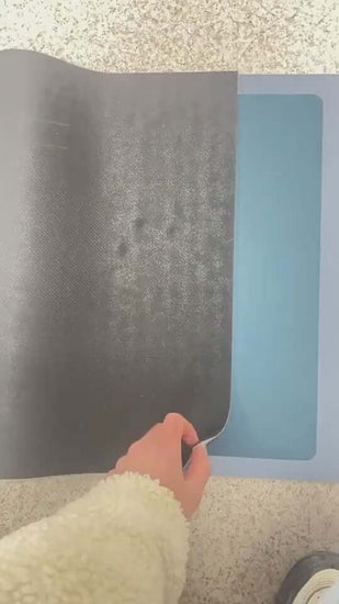 Person demonstrating a bathroom absorbent quick-drying floor mat in Baikal blue, showing its natural rubber texture.